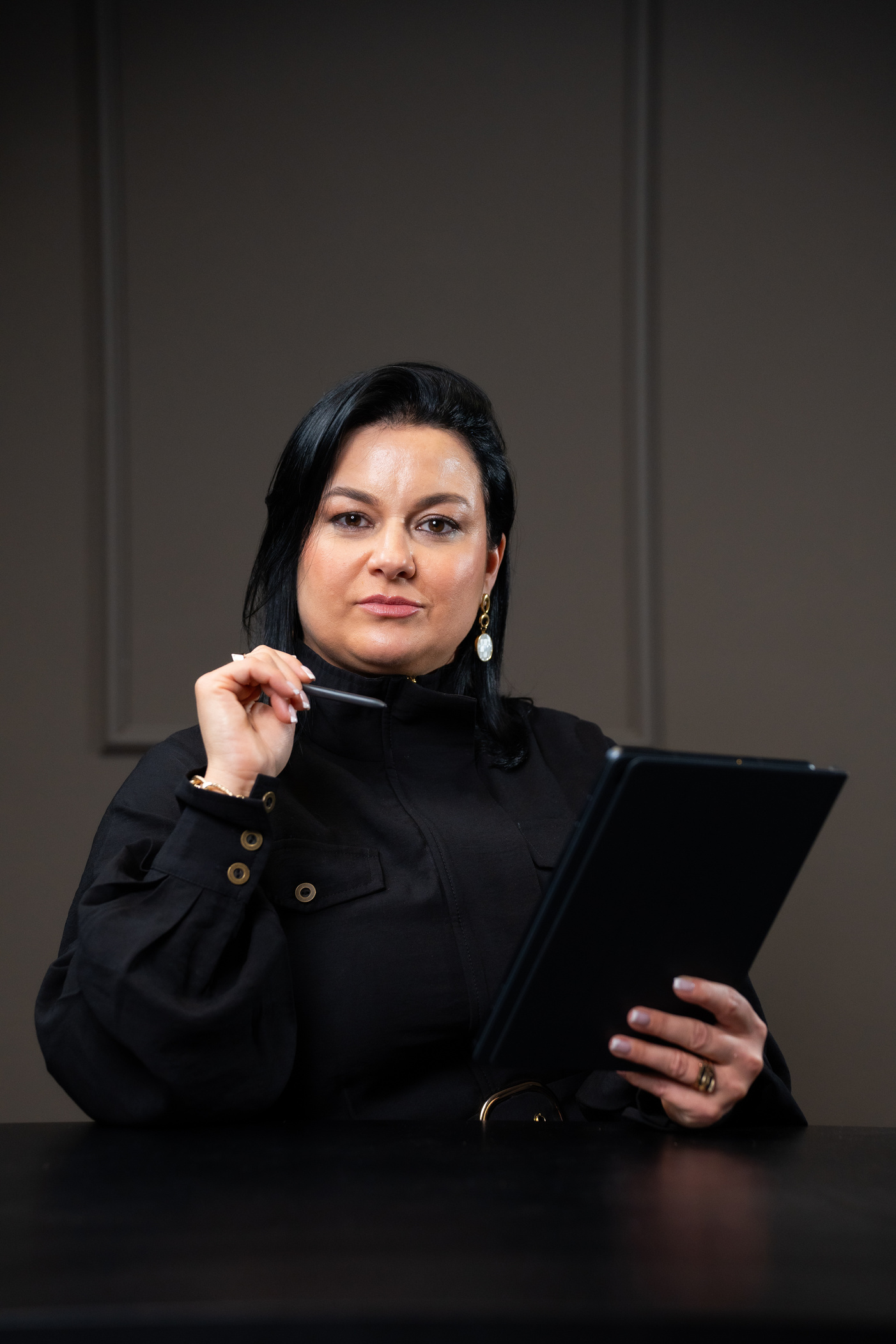 Sidnéia Sá em atendimento, segurando um tablet